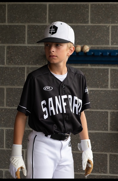 kid player in dugout with black jersey