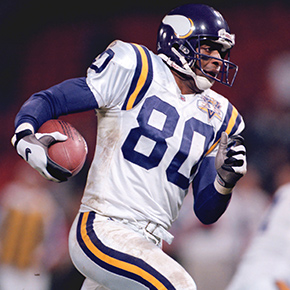 Cris Carter in Vikings uniform running with a football