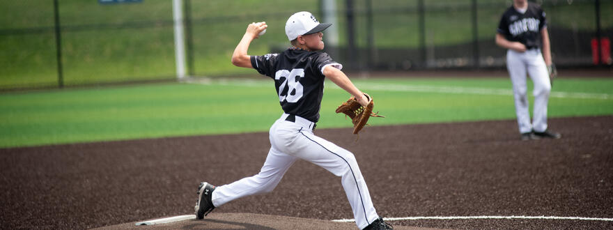 Young baseball player pitching a baseball