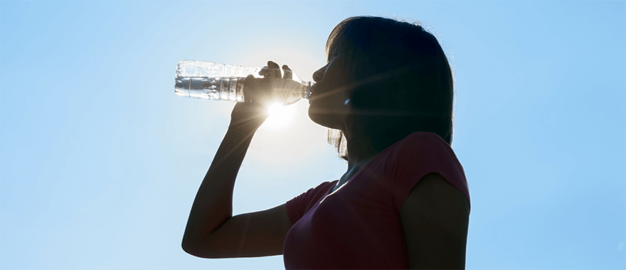 Female drinking water after working out outdoors