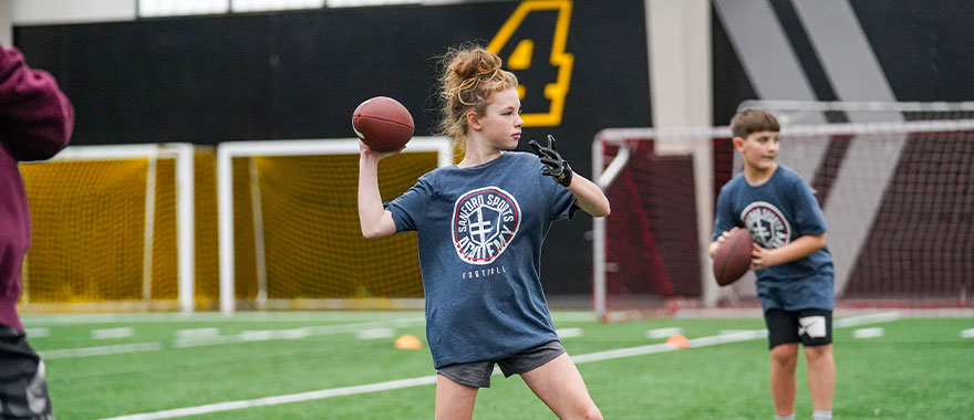 Young girl throwing football
