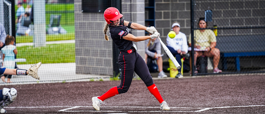 Softball player swinging bat