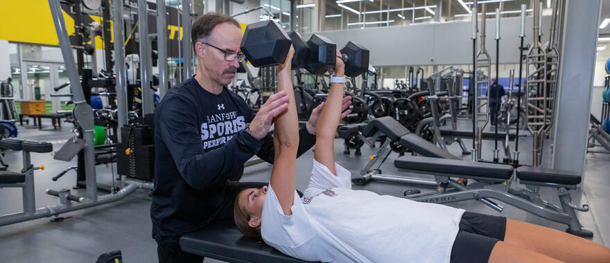 Lifting coach helping athlete