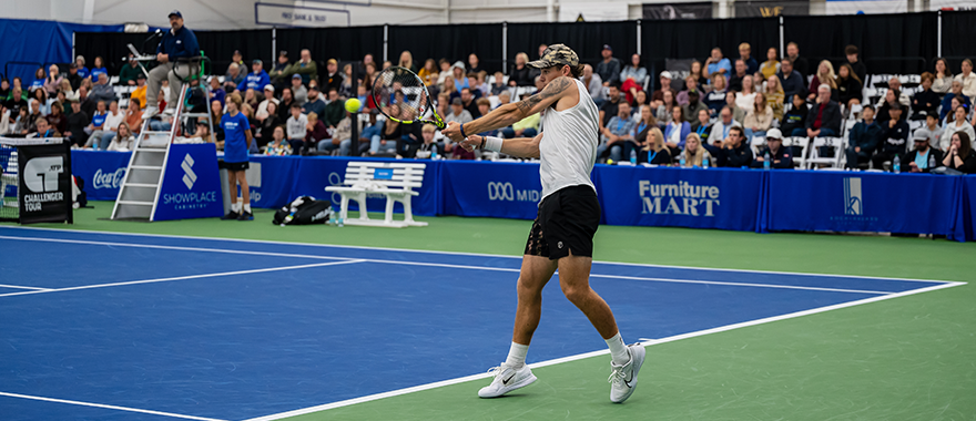 Pro tennis player swinging racket