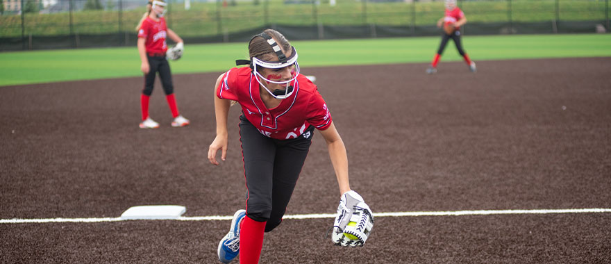 Youth softball athlete fielding ball