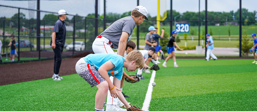 Youth athletes doing baseball drills on field