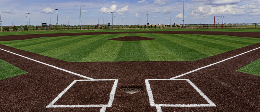 view of the sanford diamons from behind home plate with blue sky and fresh cut grass