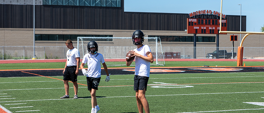 9th grade football players training on the Moorhead football field