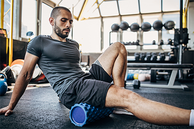 Adult male using foam roller for workout recovery