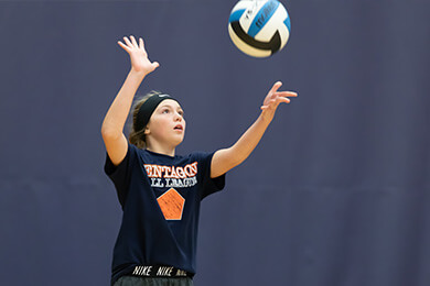 young volleyball player practicing serving
