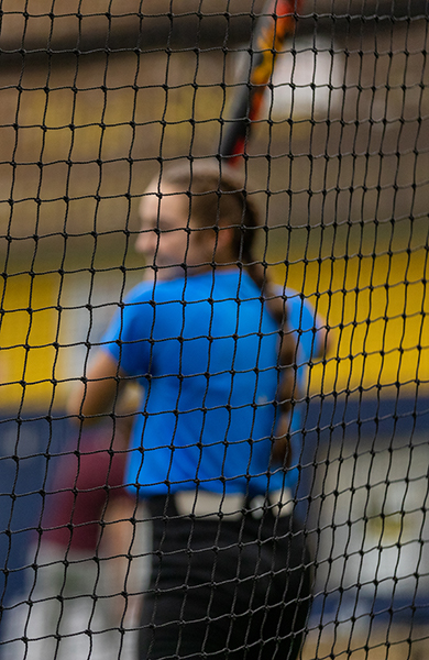 softball player at the fieldhouse, inside cages
