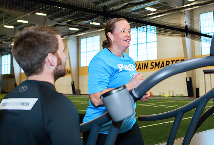 Military member Sara Hilmoe running on a treadmill at the Sanford Fieldhouse