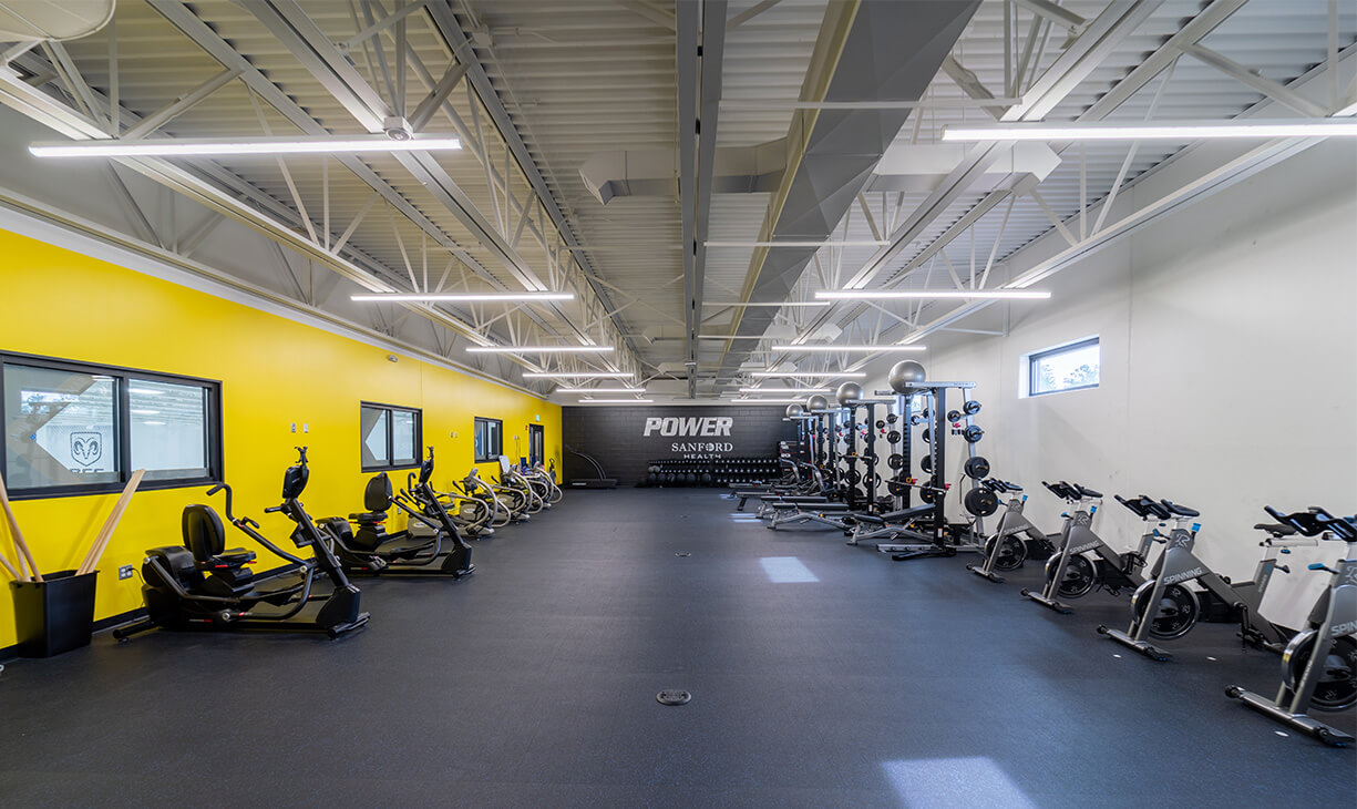 A view of the training room in Bemidji featuring stationary bikes, weight racks and free weights. 