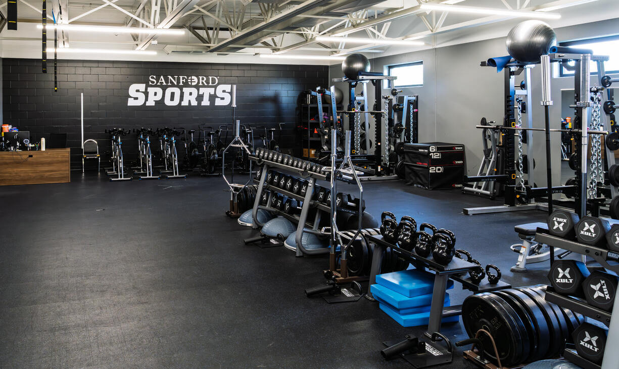 A view of the training room in Bemidji featuring stationary bikes, weight racks and free weights.