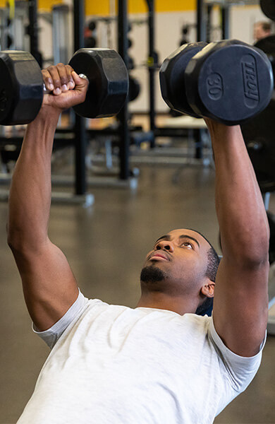 Male athlete lifting dumbells