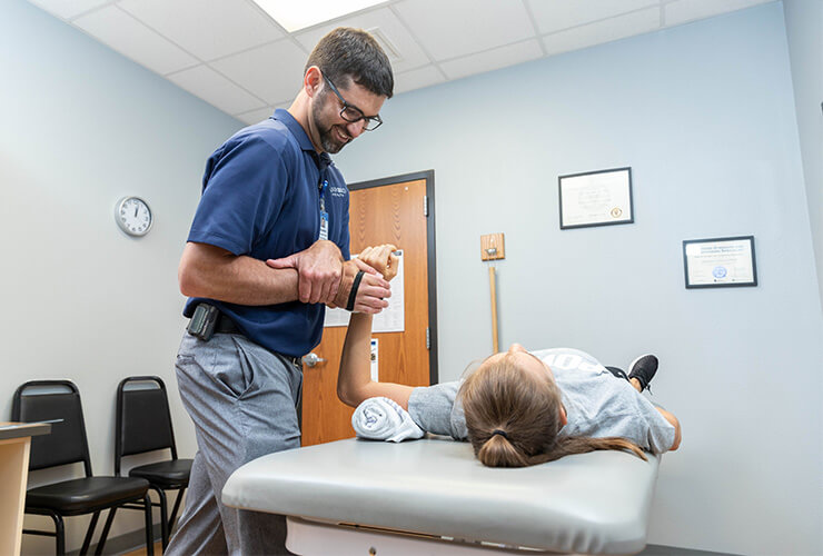 Athlete rehabbing arm injury with physical therapist
