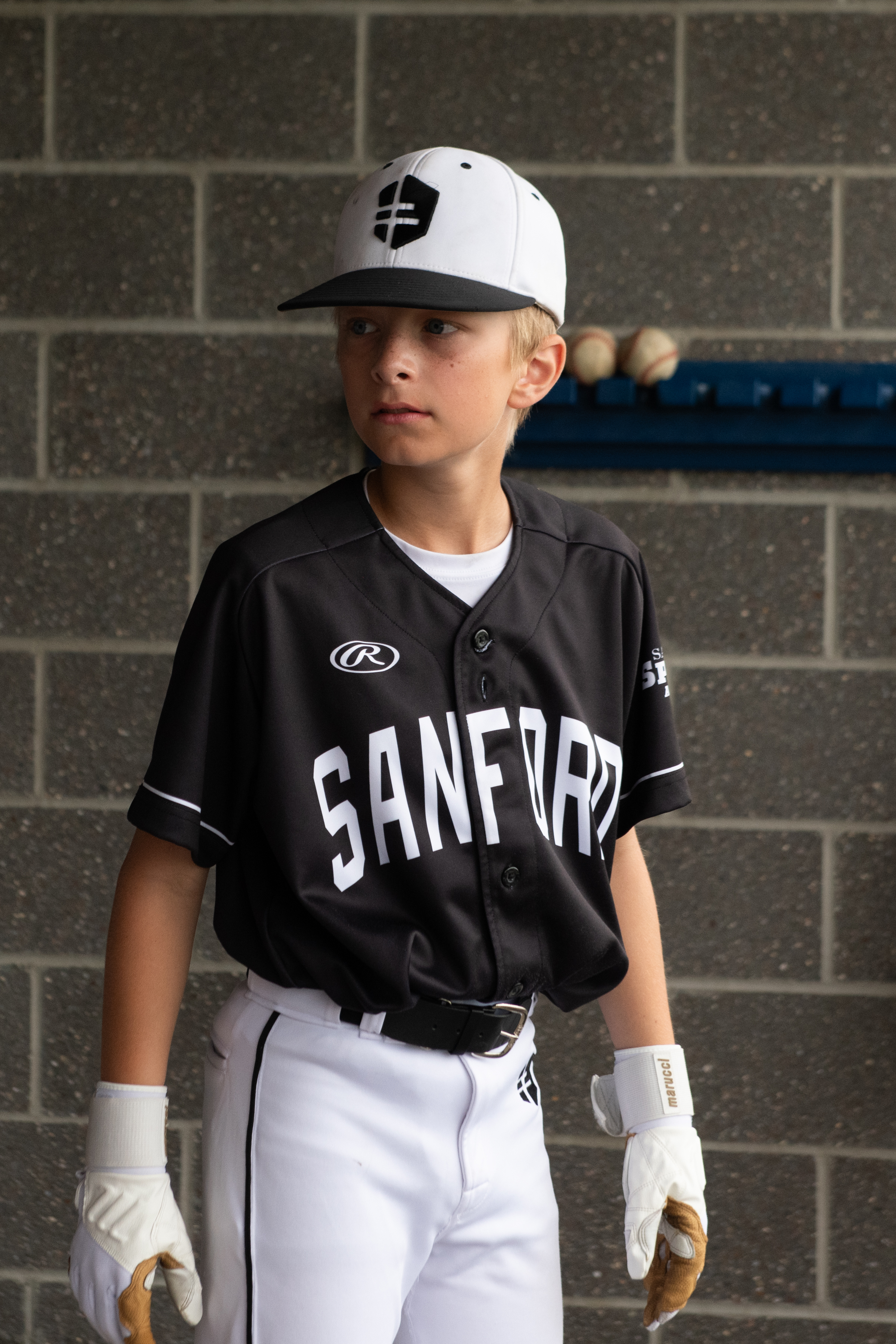 kid player in dugout with black jersey