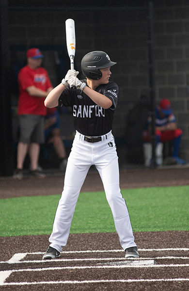 baseball player in black jersey standing above home plate ready to bat
