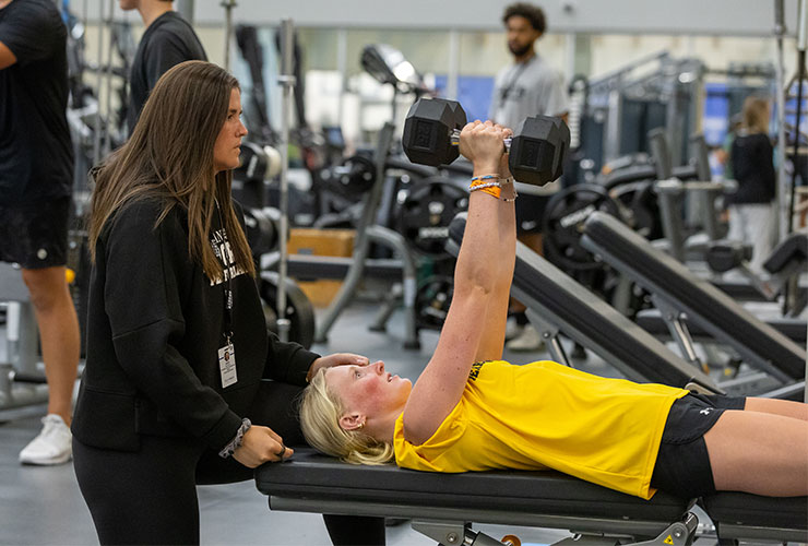 Strength coach helping young girl train
