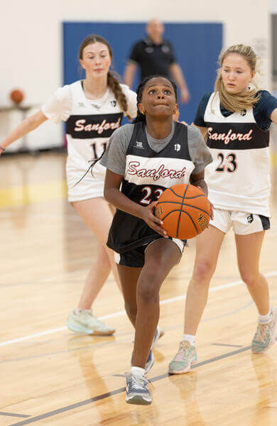 Young female basketball player going up for a layup