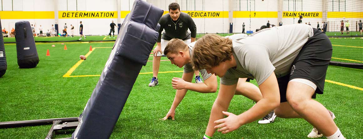football combine with two players practicing on turf