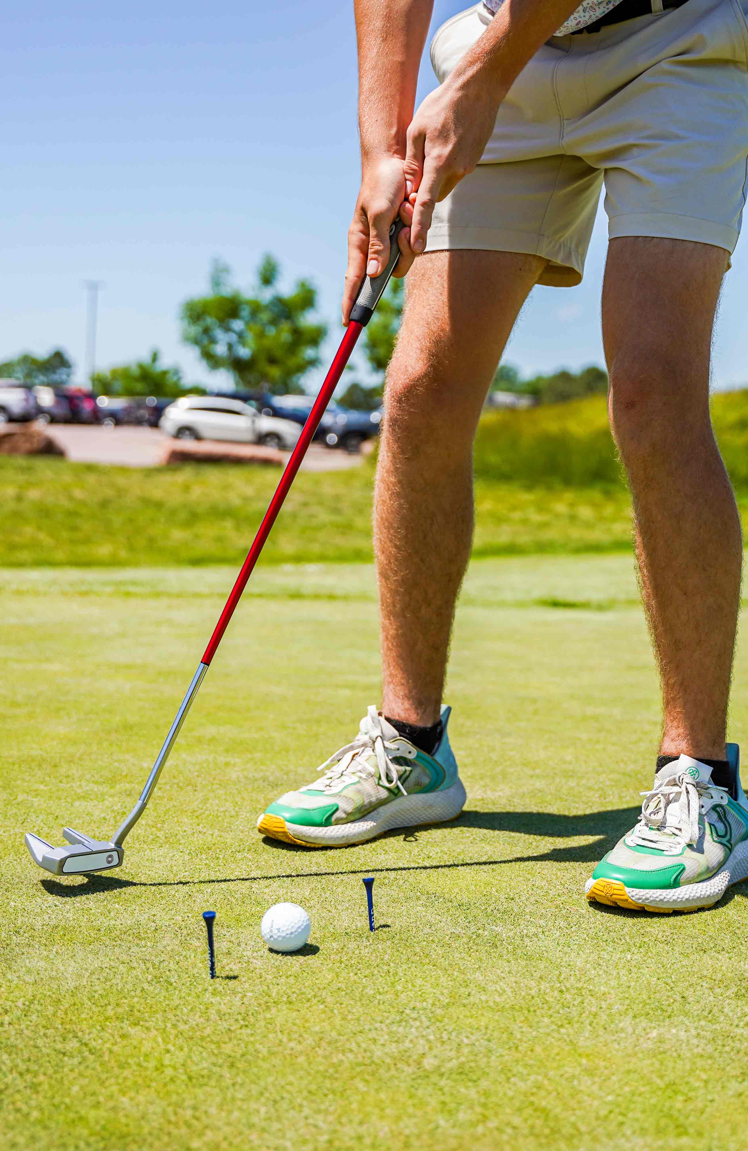 lower half of golf player's body, lining up to put the ball