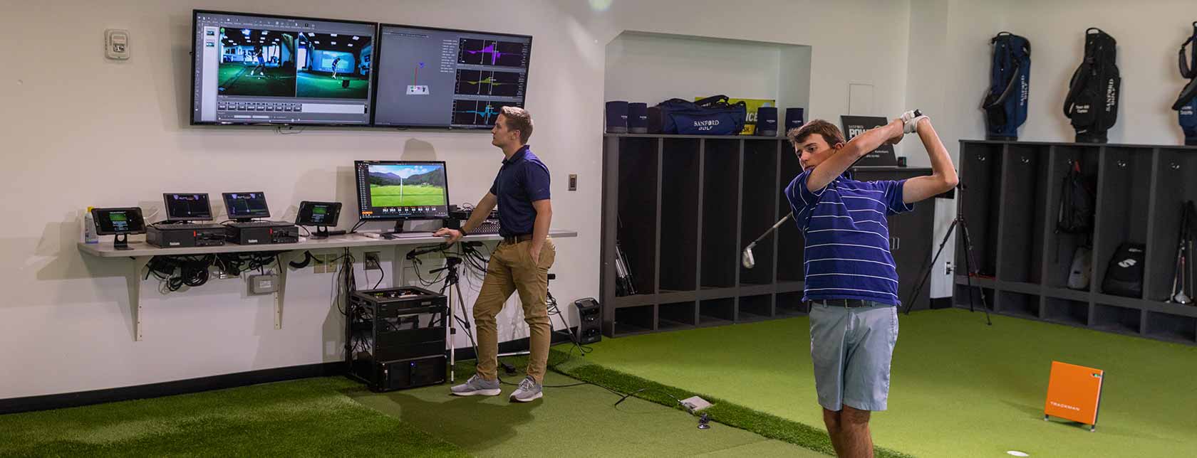 two people playing golf simulation
