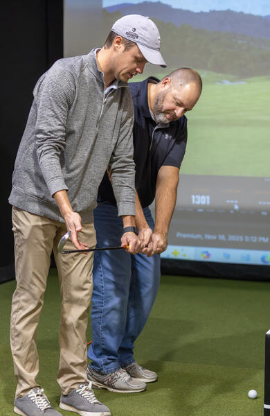 Fargo golf coach coaching adult on golf putt
