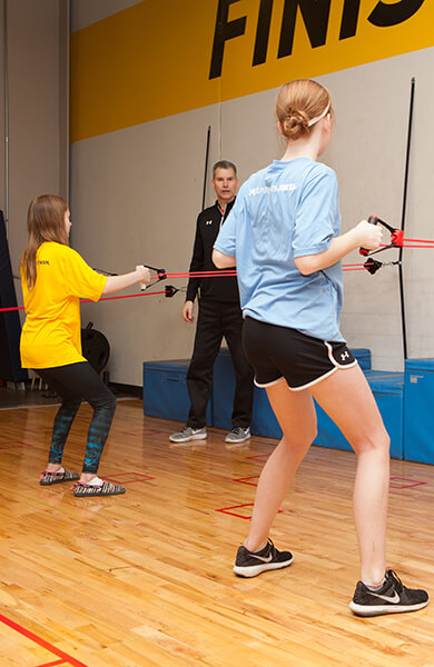 athletes using resistance bands with performance coach