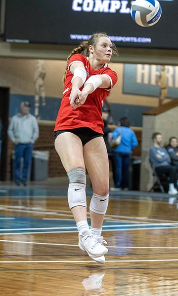 Woman preparing to hit volleyball in red shirt on the court at Sanford Pentagon